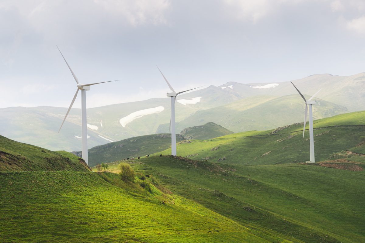 Windfarm generating electricity from the energy of strong winds blowing at the top of a high ridge in the countryside. Windfarm generating electricity from the energy of strong winds blowing at the top of a high ridge in the countryside.
