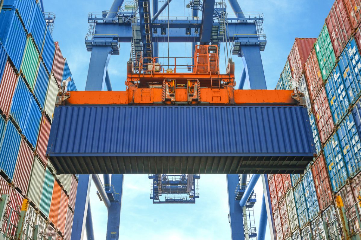 Shore crane loading containers in freight ship Shore crane loading containers in freight ship