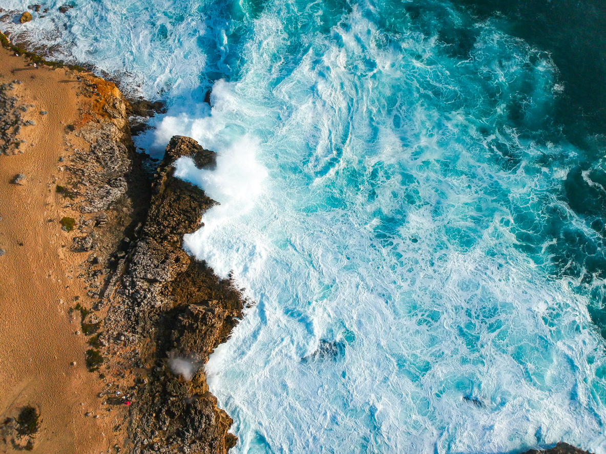 Aerial view of waves crashing against the coastline