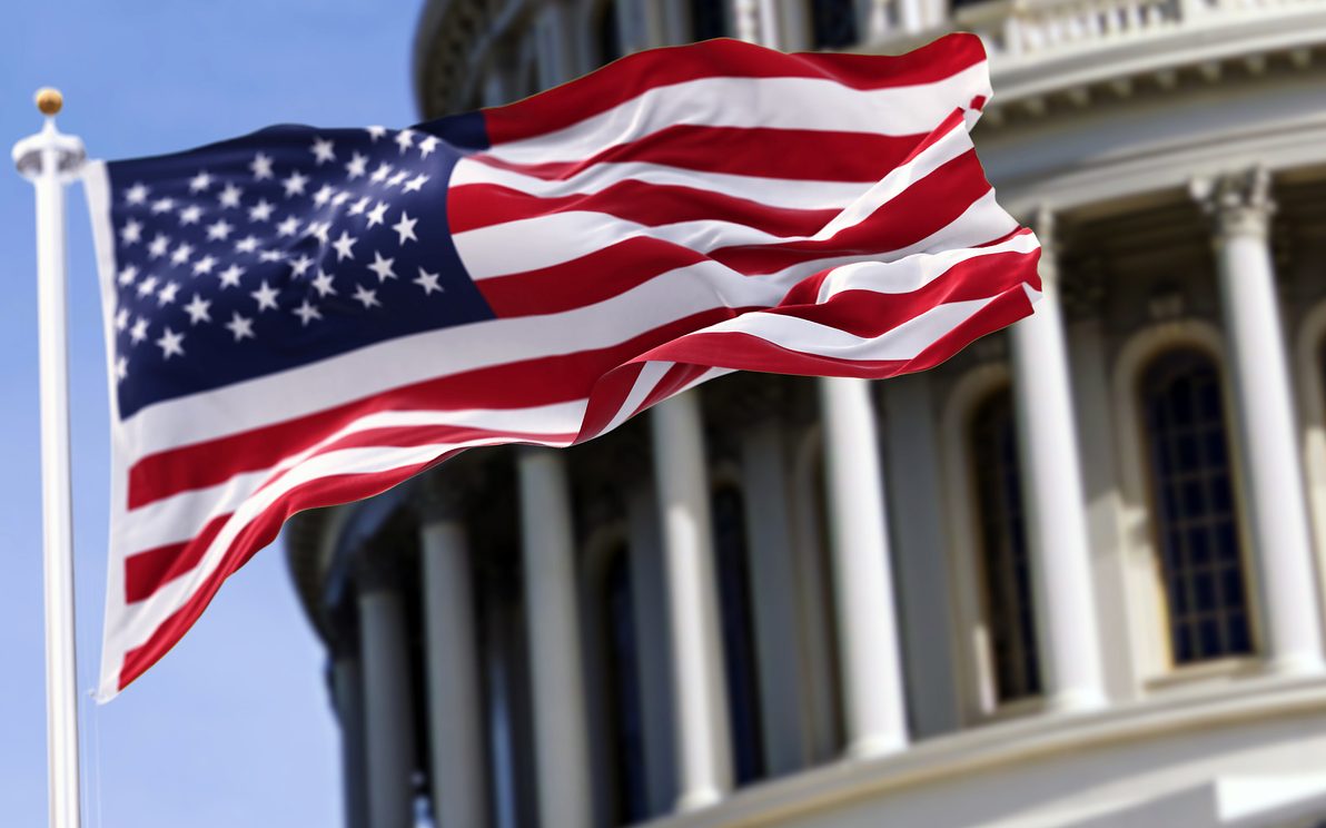 The flag of the united states of america in front of the capitol building The flag of the united states of america in front of the capitol building