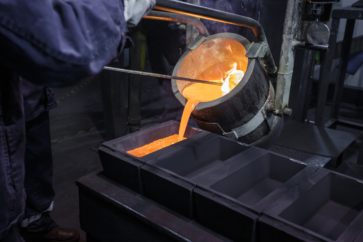Pouring hot liquid metal into molds. Pouring hot liquid metal into molds.